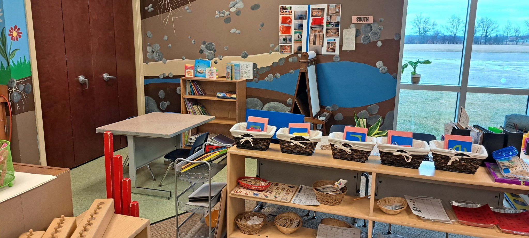 One corner of the classroom, with a few shelves, baskets, and books.